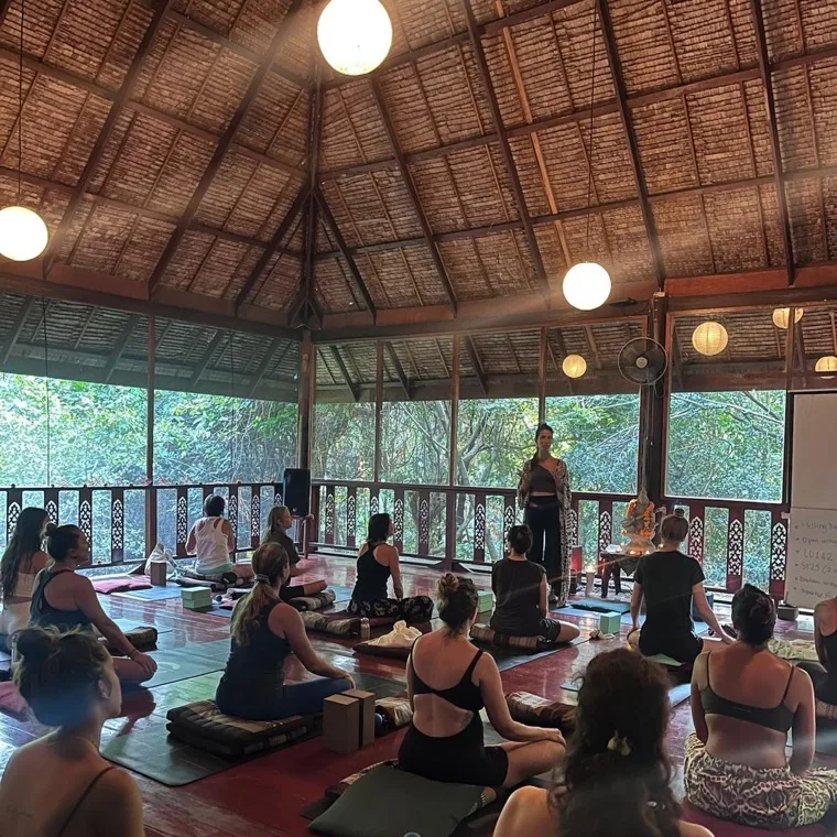 Students sitting in the open-air shala during a lecture